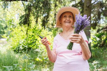 Smiling senior woman with pruning shears holding bunch of lavender flowers