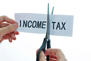Hand holding scissors cut income tax