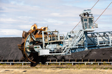 Close-up of a bucket-wheel stacker-reclaimer and a coal stockpile in a thermal power station.