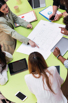 Business Team Having A Meeting At Table In Conference Room Discussing Floor Plan