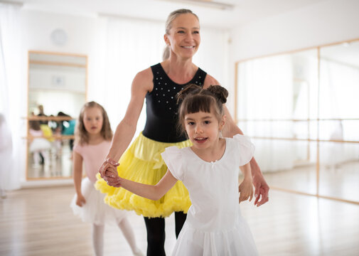 Little disabled girls learning ballet with dance lecteur in ballet studio.