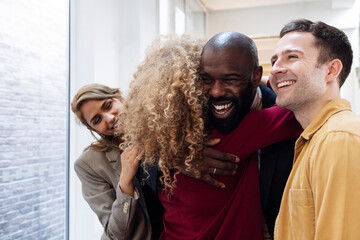 Happy business people hugging in office