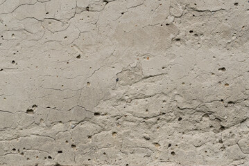 Fototapeta premium Old sandy gray plaster surface with blemishes