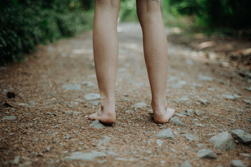 Rear view of barefoot legs walking in forest. Concept of healthy feet.