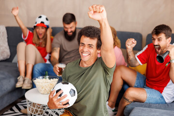 Football fans watching the game, cheering and celebrating victory