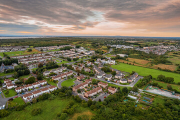Fototapeta na wymiar Aerial view on a city residential area with houses and park. Galway, Ireland. Blue cloudy sky. High density urban land.