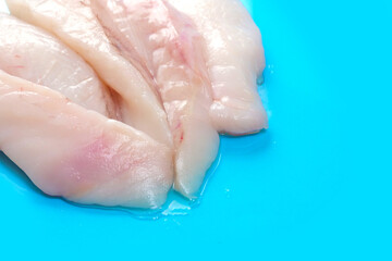 Monk fish fillets on blue ocean color surface. Seafood product with fine taste and soft tender feel. Fish monger craft.