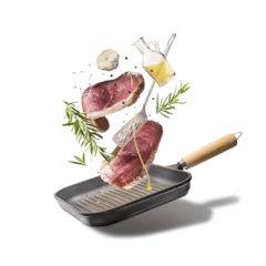 Papier Peint photo Lavable Manger Flying raw beef steaks, seasoned with herbs, oil and spices with grill pan and kitchen utensils isolated on transparent background, top view. Levitation food concept