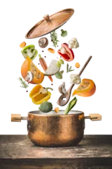 Fotobehang Healthy vegetarian cooking with pumpkin and various flying chopped vegetables ingredients, cooking pot and spoon on wooden table desk , isolated on transparent background, front view.  © VICUSCHKA