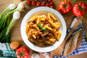 Pasta alla normal - Italian pasta with eggplant, tomato sauce and Parmesan cheese on dark background. Top view. Healthy food.