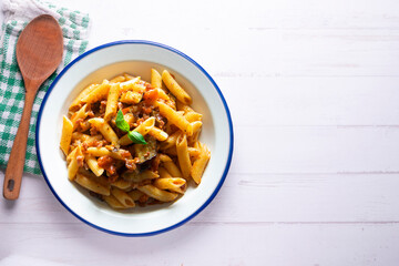Pasta alla normal - Italian pasta with eggplant, tomato sauce and Parmesan cheese on dark background. Top view. Healthy food.