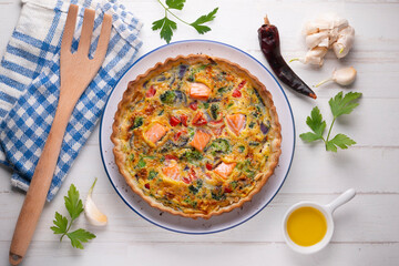 Salmon and vegetable quiche. Traditional French recipe with fish and fresh vegetables with handmade dough and egg.
