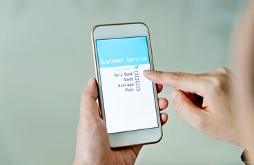 Hand holding smartphone with customer service survey form on screen