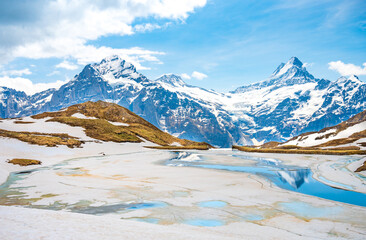 Landscape of Bachalpsee lake, covered by ice. Highest peaks Eiger, Jungfrau and Faulhorn in famous location. Grindelwald, Switzerland Alps. - obrazy, fototapety, plakaty