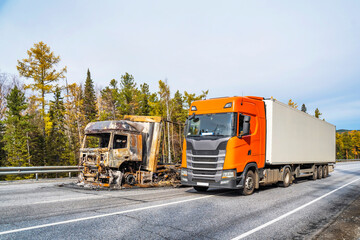 Fully burned truck drives around a whole truck on the highway. The concept of an insured event. Insurance case.