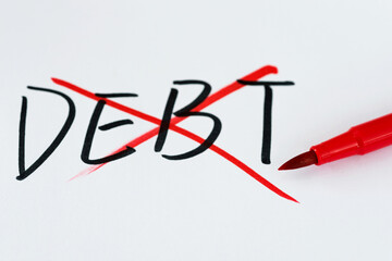 Drawing cross on word debt from white paper