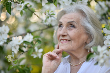 Portrait of happy senior woman smiling in autumn park