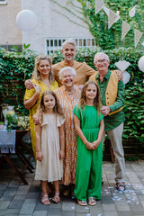 Multi-generation family on outdoor summer garden party, celebrating birthday