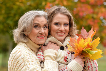 Portrait of an elderly woman with her daughter in autumn.