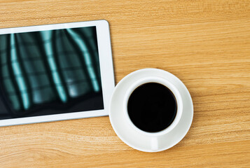 Top view of digital tablet and coffee cup on wooden table