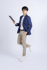 Jumping portrait of confident young Asian businessman with tablet computer