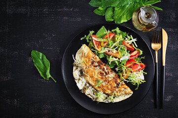 Ketogenic diet breakfast. Omelette with sorrel and tomatoes salad. Top view, copy space
