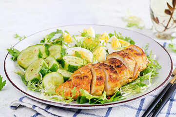 Grilled chicken meat and boiled eggs and fresh cucumber salad. Healthy keto, ketogenic lunch. Roasted chicken breast, fillet and fresh vegetable salad.
