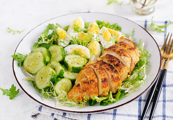 Grilled chicken meat and boiled eggs and fresh cucumber salad. Healthy keto, ketogenic lunch. Roasted chicken breast, fillet and fresh vegetable salad.