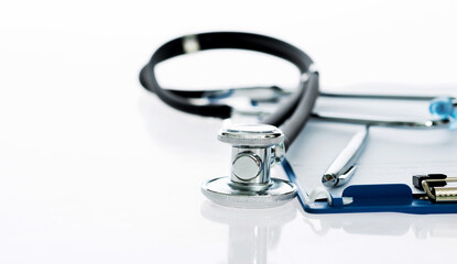 Clipboard, pen and medical stethoscope on white background