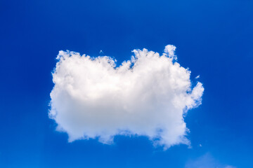 One isolated white air cloud in the blue sky. Sunny day. Partly cloudy weather forecast and a change from cyclone to anticyclone. Environment. Outdoors detail. Cute little cloud. Nature background - obrazy, fototapety, plakaty