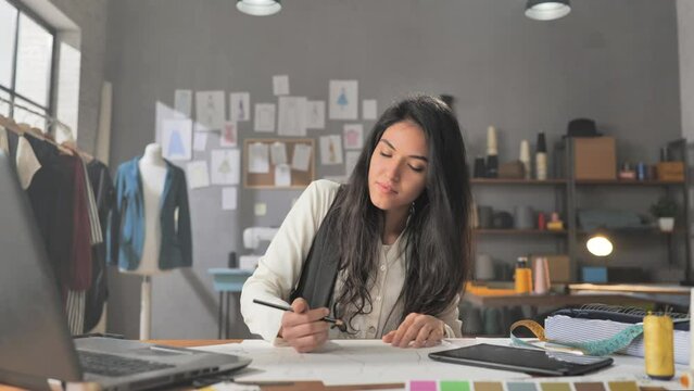 Young Female Fashion Designer Making Sketch Drawing At The Desk,arab Middle Eastern Woman Working On A Project Creates Design Clothes In Studio