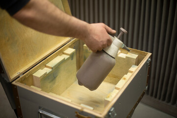 Spraying liquid on tree. Applying protective layer to board.