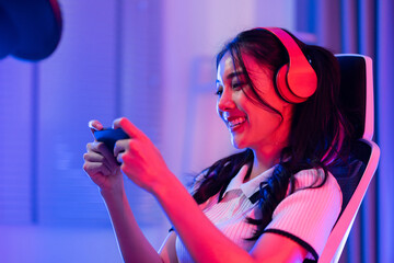 Asian young e-sport woman gamer play online mobile game on smartphone.  - obrazy, fototapety, plakaty