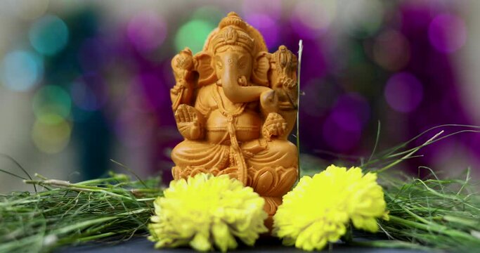 Close up shot of Hindu God Ganesh in a traditional Puja ceremony - Indian Hindu festival. Yellow flowers offered.
