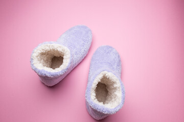 Soft blue homemade ugg boots on a pink background.