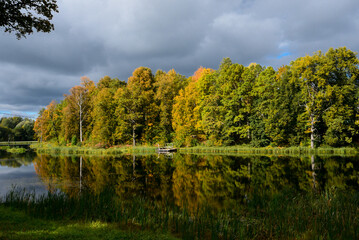 a beautiful view of the lake in autumn with the reflection of yellow-green trees and slow water in the absence of wind