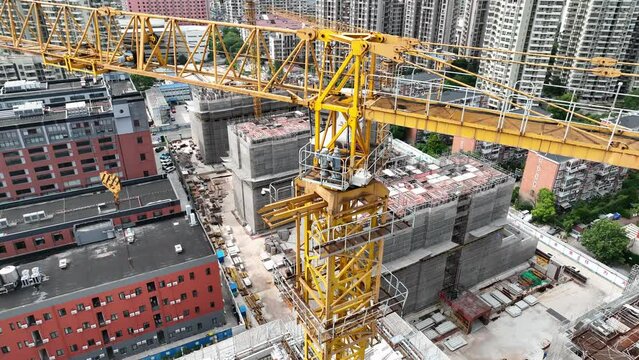 Construction site and crane in the city. Drone aerial view. Crane machine in the city with the building in the background House development.  Real estate, economy, business concept b-roll footage.