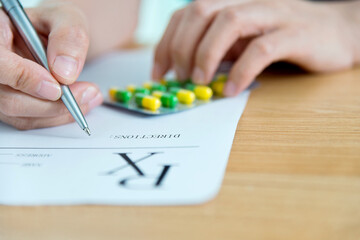 Doctor writing on prescription paper at clinic