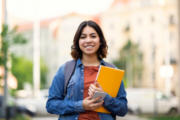 Beautiful Young Arab Female Student Standing Outdoors With Workbooks In Hands