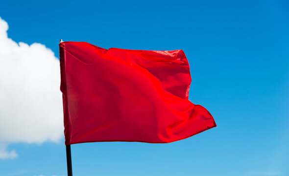 Red flag waving against blue sky