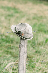 Vertical shot of traditional hunter hat on fence in Bavarian style in the Austrian Alps