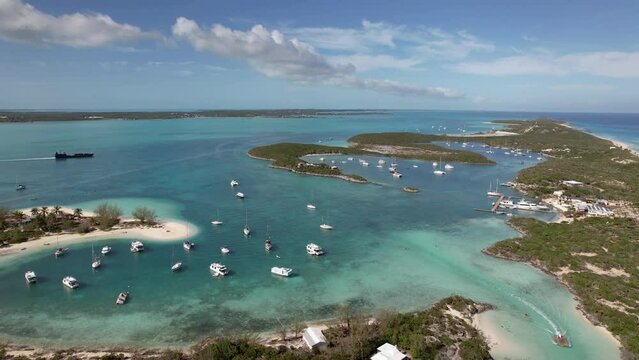 Drone aerial footage of anchored sailing yacht in emerald Caribbean sea, Stocking Island, Great Exuma, Bahamas.