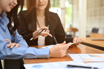 cropped shot, Two young Asian businesswomen working on a financial analysis project