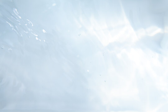 Blurred ripple water texture on white background. Shadow of water on sunlight. Mockup for product, spa or travel background. Marble water surface as wallpaper background