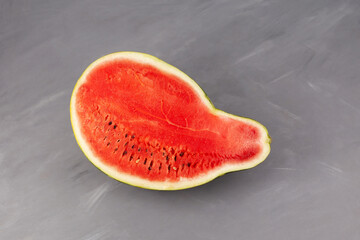 Half of pear-shaped watermelon. Deformed ugly watermelon. Concept - Food waste reduction. Eating...