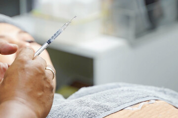 Closeup and crop hand of beauty doctor holding beauty skin syringe   prepare skin injections for customers.