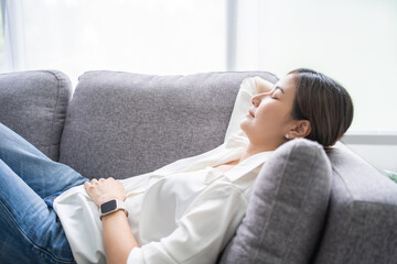 Young asian woman lying relaxing on couch in living room. She take nap or daydream, Close-up photo.