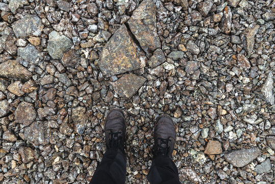 Worn boots on rough rocky footpath, directly above
