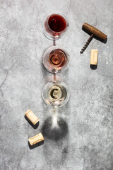 Wine composition with beautiful sunlight and shadows on grey background. Top view, flat lay