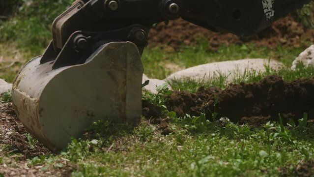 Excavator bucket digging fresh dirt (4k 30p Slow Motion)